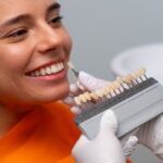 A imagem mostra um exemplo de uma mulher se preparando para a aplicação de uma faceta dentária.